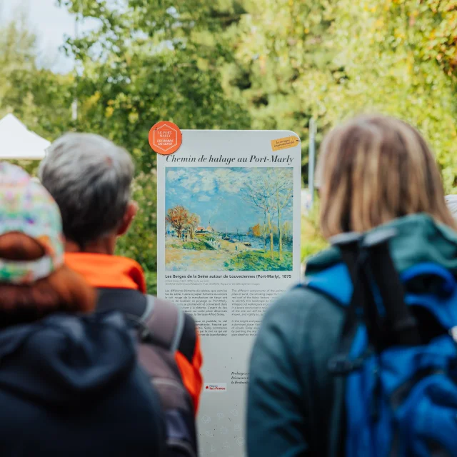 Groupe de randonneurs devant un panneau du Chemin des Impressionnistes au Port-Marly