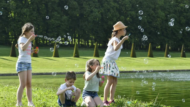 Enfants qui s'amusent à faire des bulles dans le Domaine de Marly.
