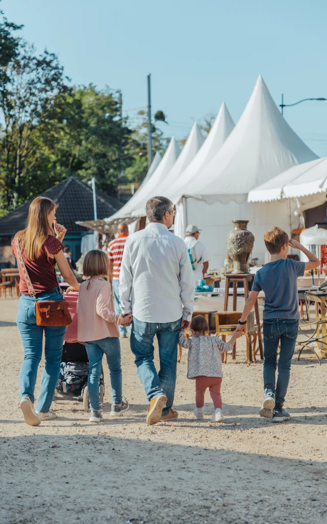 Famille avec les deux parents et les trois enfants marchant de dos à la foire de Chatou